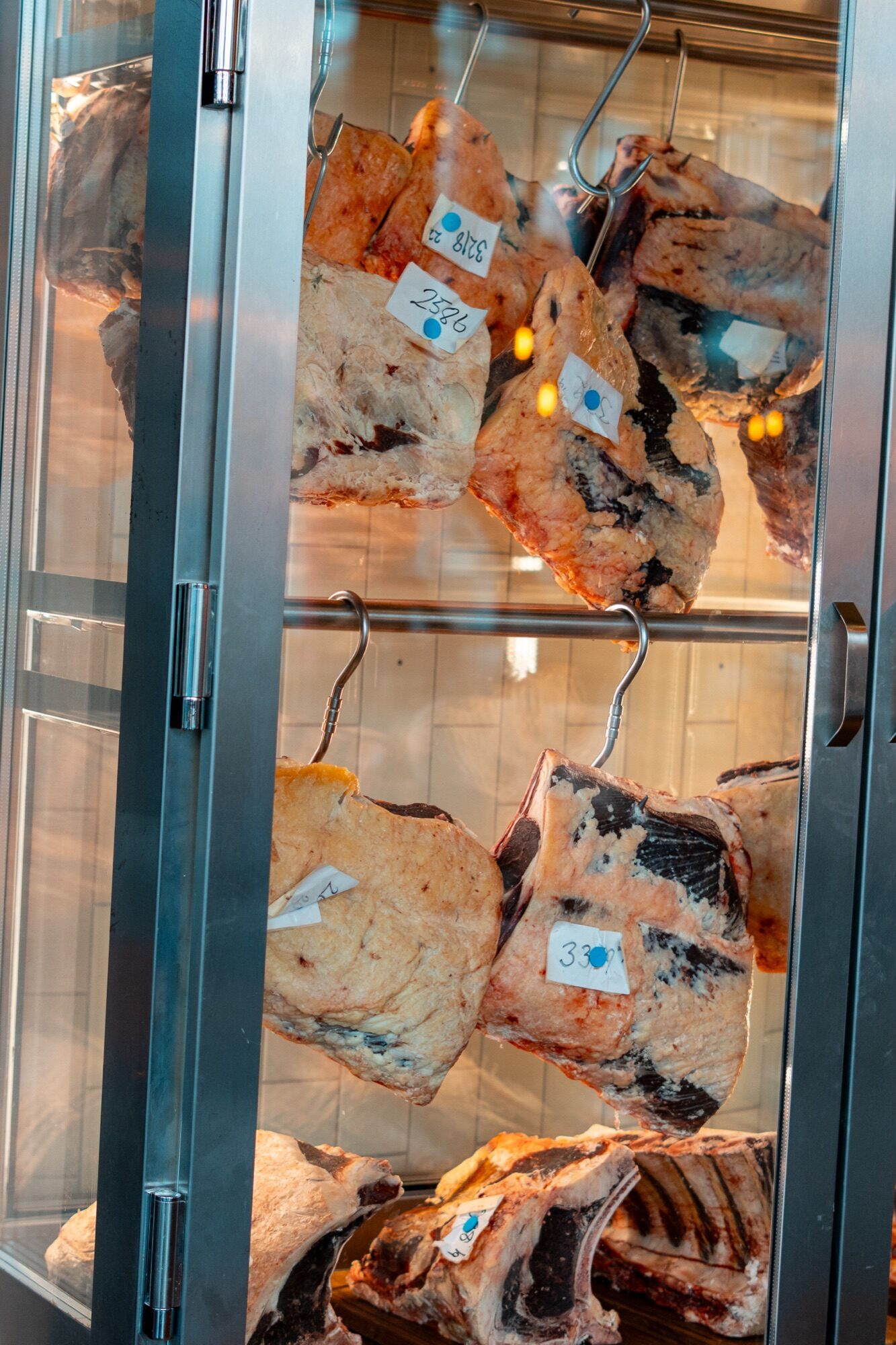 Dry aging-skåp med hängande hängmörat kött